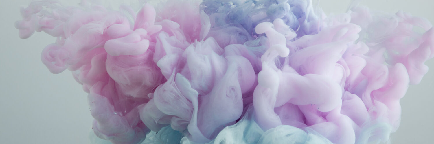 Close up view of light blue, pink and purple paint swirls isolated on grey