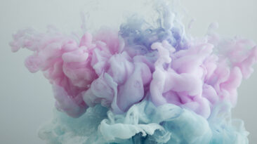 Close up view of light blue, pink and purple paint swirls isolated on grey