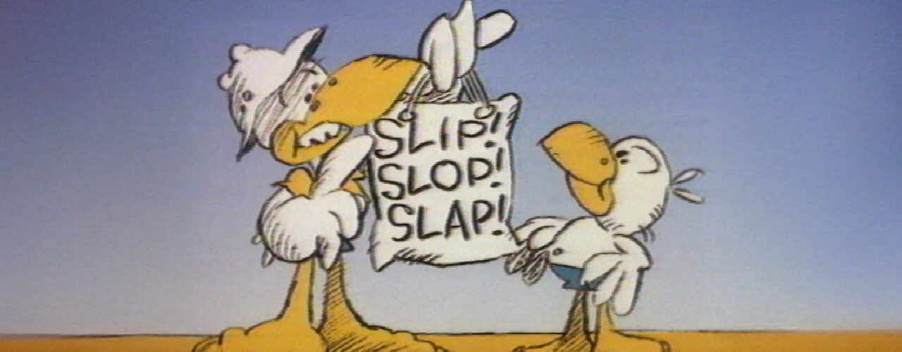Slip Slop Slap still image from the Australian sun safety campaign showing two cartoon seagulls, one taller seagull leaning in with an arm around a hanging sign that reads Slip Slop Slap, and a smaller seagull standing to the right, with a sandy ground and blue sky behind them